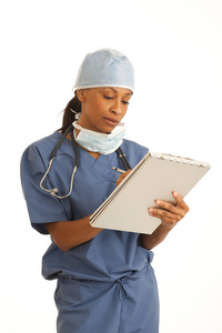 年轻的黑人女外科医生穿着手术服在剪贴板上做笔记