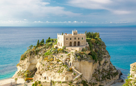 圣玛丽亚戴尔伊索拉修道院圣塔玛丽亚伊索拉教堂，位于泰尔赫尼亚海的岩石之上，绿树蓝天，白云围绕在晴朗的日子里，意大利南部的托