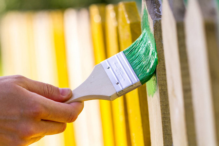 粉刷栅栏用绿色油漆粉刷木栅栏照片