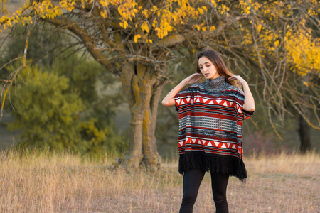 一个穿民族毛衣的女孩的秋日肖像