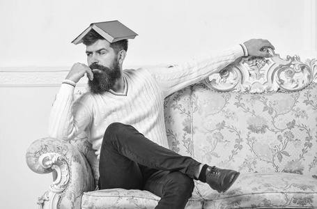 厌倦了阅读男子气概坐在头上, 像屋顶的开放书.枯燥的文学观念.