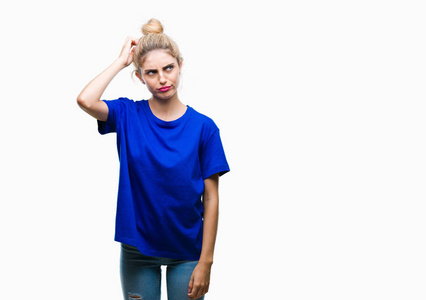 年轻漂亮的金发碧眼的女人穿着蓝色的T恤，在孤立的背景下困惑和好奇的问题。 不确定，带着怀疑的想法，手在头上。 沉思的概念。