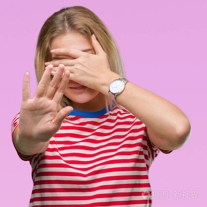 年轻的高加索女人在孤立的背景上用手遮住眼睛,用悲伤和恐惧的表情做