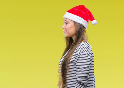 年轻美丽的高加索女人戴着圣诞帽，在孤立的背景下，看着侧面放松的轮廓，自然的脸，自信的微笑。