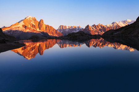 日落时美丽的山脉天际线景观，阿尔卑斯山全景，湖中倒影，自然背景与共空间