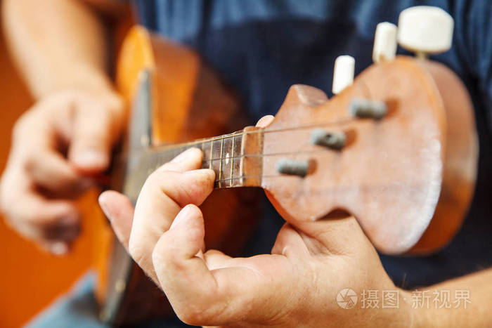 男人在室内玩曼陀林阳光明媚双手特写