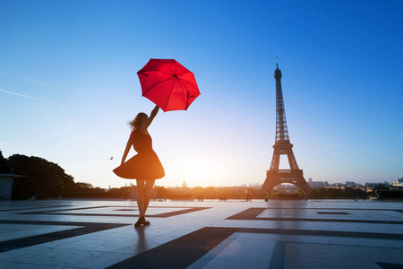 去巴黎旅行，埃菲尔铁塔附近带着红伞的美丽女孩的剪影