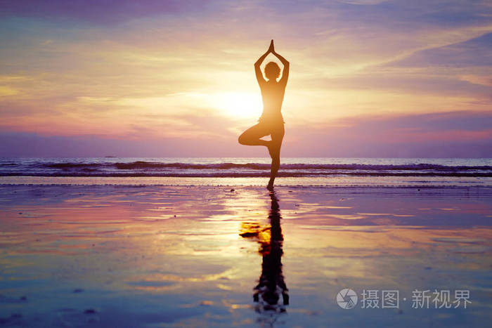 女性在海滩上的瑜伽剪影健康和谐背景生活平衡