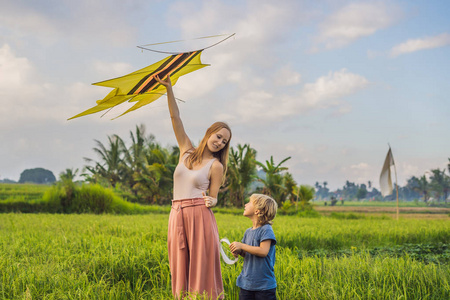 母子在印度尼西亚乌布巴利岛的稻田里放风筝。