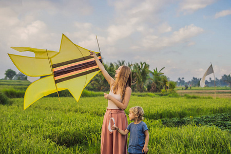 母子在印度尼西亚乌布巴利岛的稻田里放风筝。