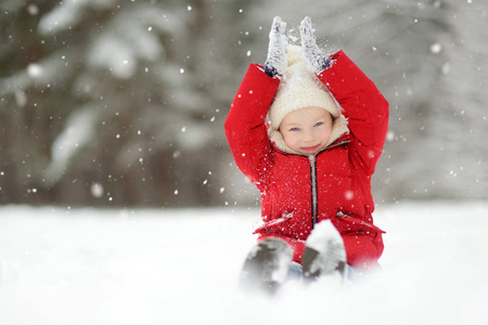 可爱的小女孩在美丽的冬季公园玩得开心