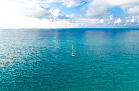鸟瞰美丽的，令人惊叹的泰瑞尼亚海，绿松石水，热带海景，无边无际的地平线，明亮的蓝天和白云，小游艇背景，意大利南部的托洛佩亚卡拉布