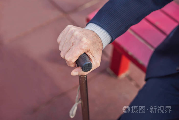 老人手拿着拐杖户外