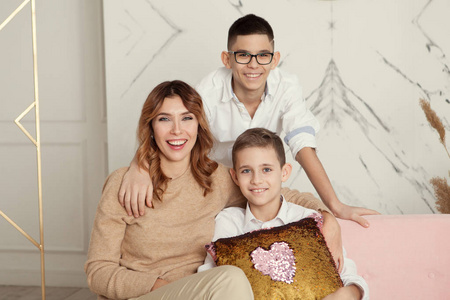 美丽的家庭肖像母亲和儿子坐在室内沙发上