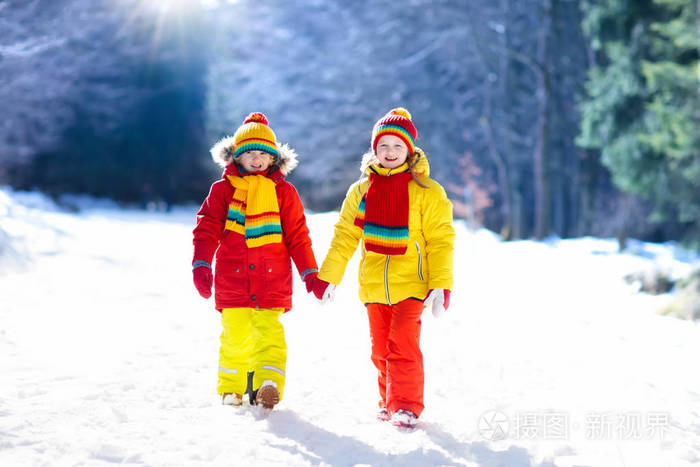 孩子们在下雪的冬天在户外玩耍. 男孩和女孩在降雪风暴中捕捉雪花.