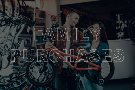 家庭购买。 顾客为自己选择自行车。 顾客是夫妻。 持有自行车的顾客。 给小孩子骑自行车。 夫妻幸福而微笑。 自行车店。