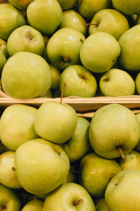市场上的盒子里放着一堆新鲜成熟的绿苹果