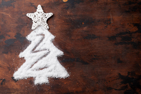圣诞树形状的雪和白色星星装饰木制背景