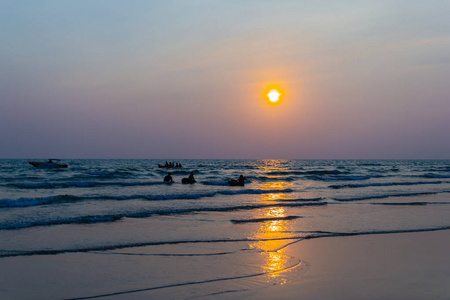 人们在海滩上玩日落和剪影亚洲泰国。