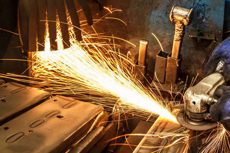 用电砂轮机喷出的火焰火花改变前后摇摆的状态照片