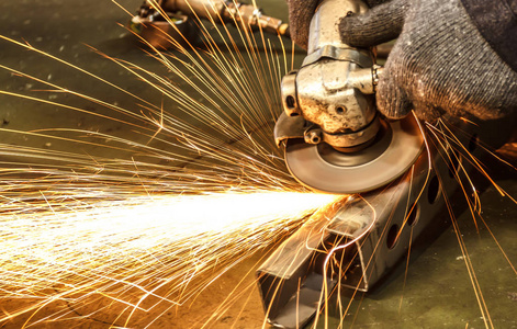 用电砂轮机喷出的火焰火花改变前后摇摆的状态照片