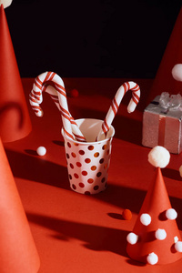 彩色纸和纸玻璃制成的创意圣诞树，红色背景上有糖果棒