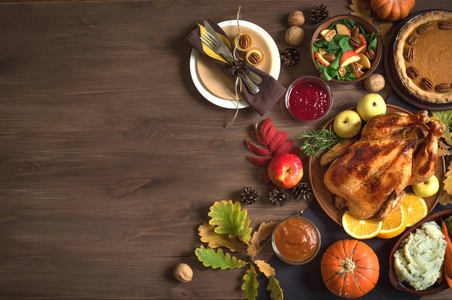 感恩节晚餐背景与火鸡和各方菜肴南瓜派落叶桌设置和季节性秋季装饰顶部视图复制空间。