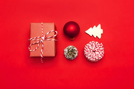 s wooden toys, fir cones, red ball, snowflake, gift twine on red