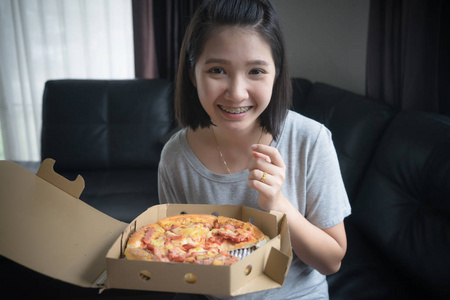 快乐的女孩在家吃披萨