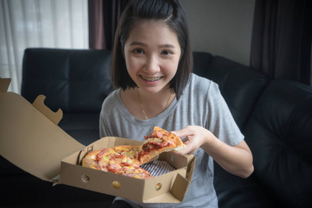 快乐的女孩在家吃披萨