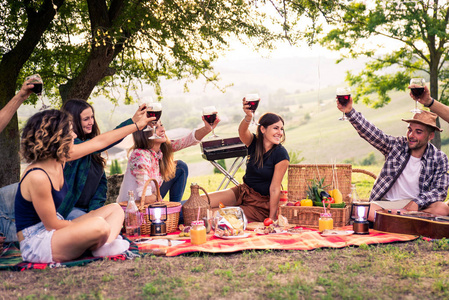 一群年轻快乐的朋友，在乡下的一个烧烤聚会上，在户外野餐，人们一边玩，一边庆祝