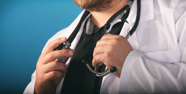 男性医学治疗医生手拿听诊器在他的胸部在手特写。 医生正在等病人检查