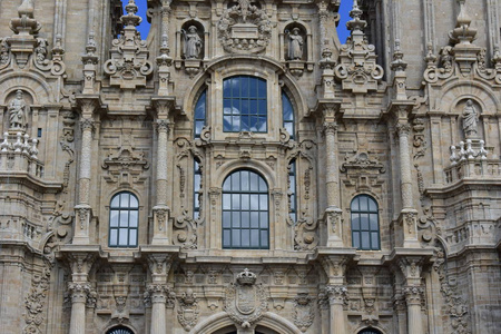 大教堂。 巴洛克式立面特写窗户，有云反射。 柱子，雕像，玻璃和细节。 圣地亚哥德堆肥拉奥布拉多罗广场。 西班牙。