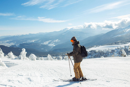 好男人在山上滑雪。 在雪山上滑雪很好，冬天是第一次降雪。 滑雪胜地季节开放。 滑雪设备小径。