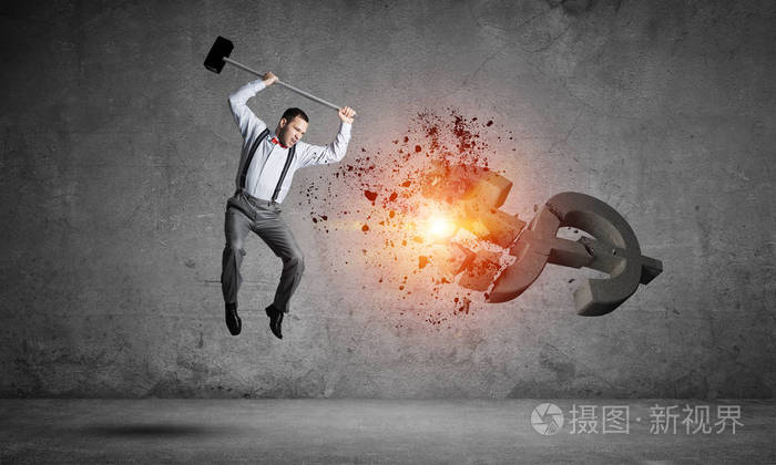 年轻暴怒的商人用锤子砸碎了美元符号
