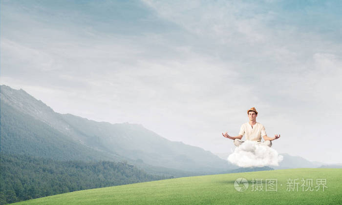 年轻人闭上眼睛集中注意力在空中沉思云背景上有明亮美丽的风景