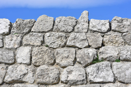一堵石头砌成的墙在天空上的碎片.照片