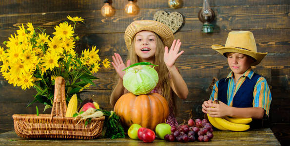 秋收节。庆祝丰收节。孩子们玩蔬菜木制背景。孩子们的女孩男孩戴帽子庆祝收获节乡村风格。小学秋季节日理念