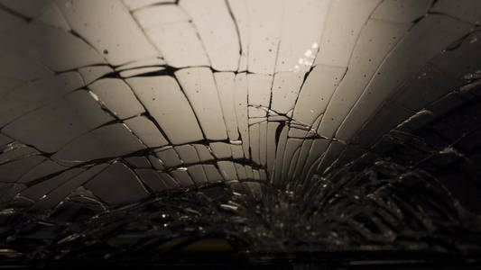 长锤子敲击特写宏观的碎黑玻璃.抽象的黑色背景.