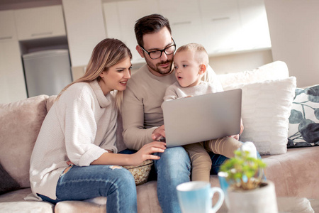 年轻夫妇在家里的现代客厅工作笔记本电脑的房子金融.照片