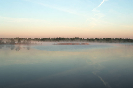 河上的一个小岛上满是雾。 蓝天反射在水中。