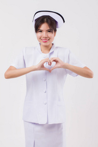  studio isolated portrait of asian female nurse doing heart gest