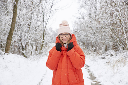 特写肖像照片，一个快乐的中年妇女戴着帽子，站在户外，享受冬天的天气。