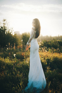 田野里的浪漫女孩。 漂亮的白色礼服