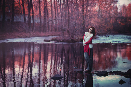 秋天森林里的女孩。 湖中的童话倒影