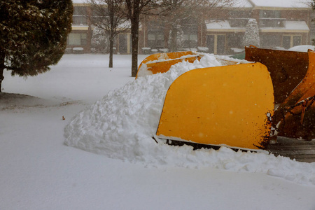 扫雪车在雪地的街道上工作，用一个反铲把雪从雪中移除