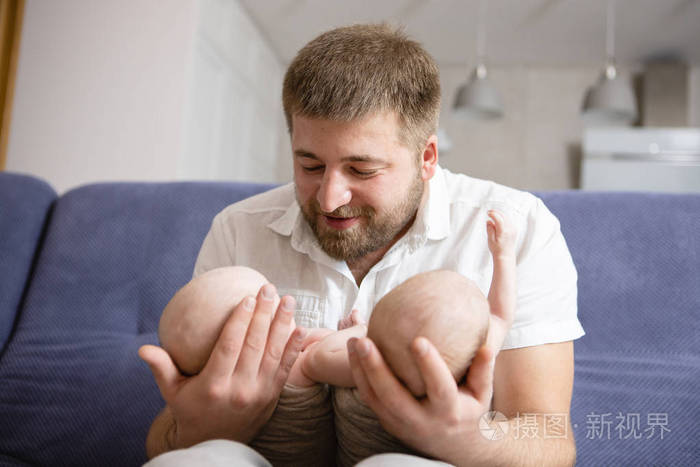 幸福的父亲两个孩子一个年轻的父亲和他新生的双胞胎女儿