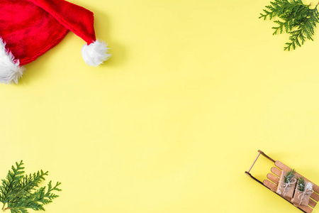 圣诞相框制成的礼物圣诞树树枝和红色圣诞帽背景与复制空间的文本顶部视图