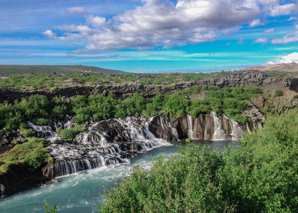 美丽和不寻常的自然现象熔岩瀑布Hraunfossar阿祖尔水渗透到熔岩中，像小瀑布和急流一样流入黑维塔河，博尔格夫乔杜尔地区，