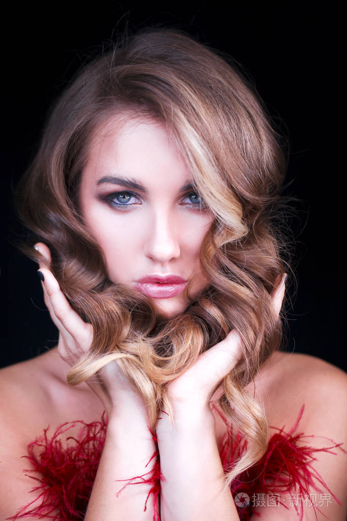 漂亮的金发女郎穿着红色性感的连衣裙. 健康的长卷发.